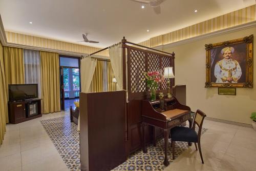 a living room with a desk and a television at Royal Orchid Metropole Mysore in Mysore