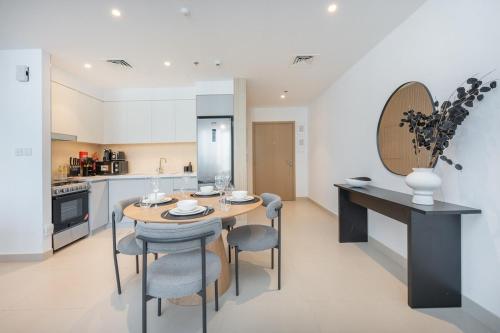 a kitchen and dining room with a table and chairs at Free housekeeping visits during your stay - StayShort - Captivating 1BR apartment in Dubai Creek Harbour in Dubai
