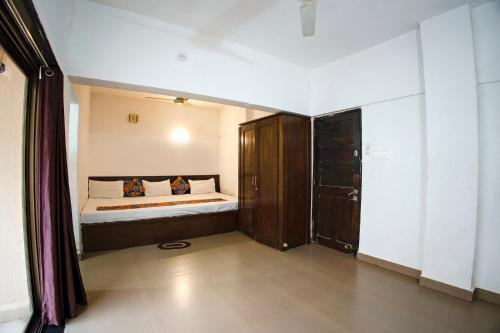 a small bedroom with a bed and a closet at FabHotel Comfort Stays - Nr Miramar Beach in Panaji