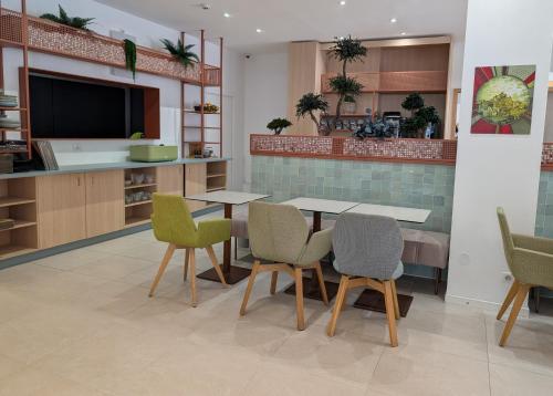 a dining room with a table and chairs and a kitchen at Hôtel Carré Vieux Port in Marseille