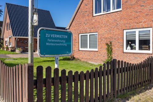 a sign in front of a fence in front of a house at Süsse 2 Zimmerwohnung in Heiligenstedten