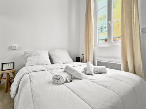 - un lit blanc avec des serviettes dans la chambre dans l'établissement Appartement Cosy 4P - Marais, à Paris