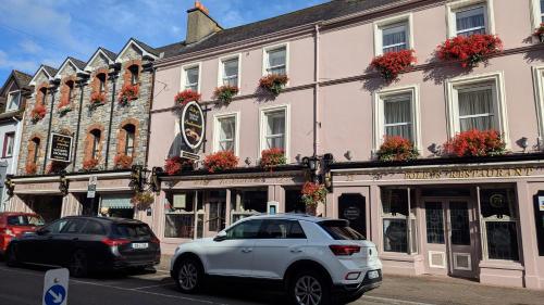 a white car parked in front of a building at Foley's Townhouse Killarney in Killarney
