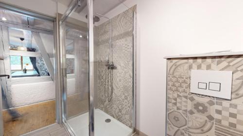a shower with a glass door in a bathroom at Les Appartements Manala - Turckheim in Turckheim