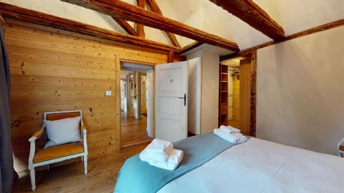 a bedroom with a bed and a chair at Les Appartements Manala - Turckheim in Turckheim