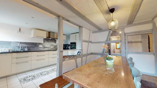a kitchen with a wooden table in a room at Les Appartements Manala - Turckheim in Turckheim
