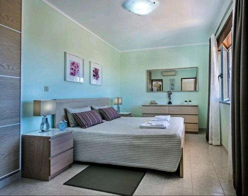 a bedroom with a large bed and a mirror at VILLA SALGADOS, near ALBUFEIRA, with Private Pool, 5 minutes from Gale Beach in Guia