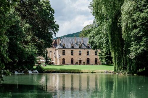 an old castle with a pond in front of it at Abbaye de la Bussière in La Bussière-sur-Ouche