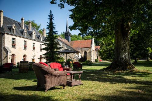 a yard with chairs and a table in front of a building at Abbaye de la Bussière in La Bussière-sur-Ouche