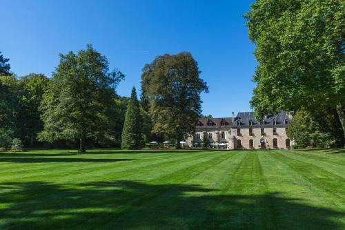 a large grass field in front of a castle at Abbaye de la Bussière in La Bussière-sur-Ouche