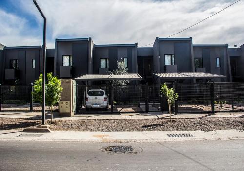 a van parked in front of a black building at Depto del Bosque, 4 personas, patio, cochera cubierta ,parrilla in Maipú