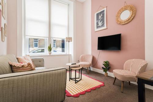 a living room with a couch and chairs and a tv at 4 Beds - City Gateway Getaway with Free Parking in Glasgow