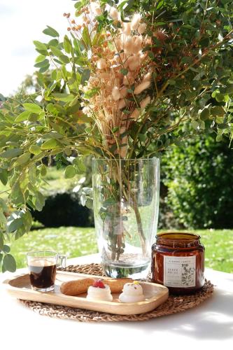 a table with a vase with flowers and a plate with dumplings at Gîte de l’Ambiance in Francheville