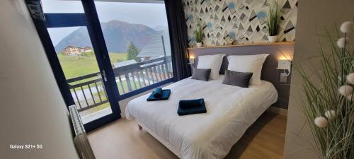 une chambre avec un lit avec une grande fenêtre dans l'établissement hotel la rua, à Albiez-Montrond