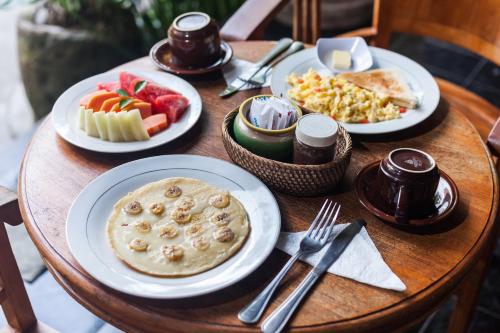 a wooden table with plates of food on it at Rumah Weda in Ubud