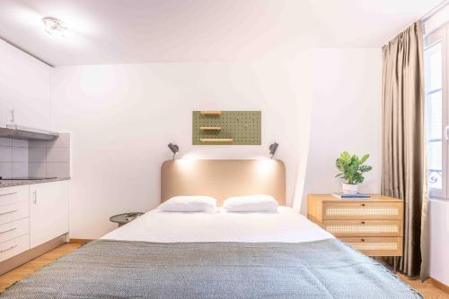 a bedroom with a large bed and a kitchen at Saint Laurent 33-35 by Homenhancement in Lausanne