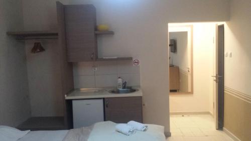 a small kitchen with a sink and a bed at Apartments Fortunella in Budva