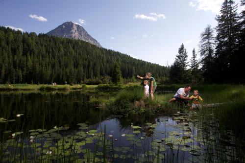 a group of people standing in the grass near a lake at Apart Diamant in Nauders