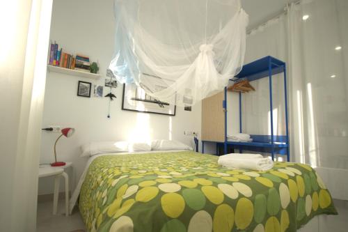 sypialnia z łóżkiem z zielonym i żółtym kocem w obiekcie Livingtarifa Apartamento La Palmera w mieście Tarifa