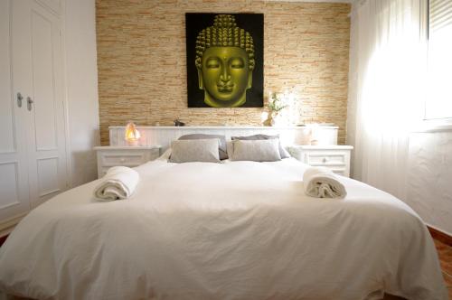 a bedroom with a large white bed with a gold head at Livingtarifa Chalet La Caracola in Tarifa