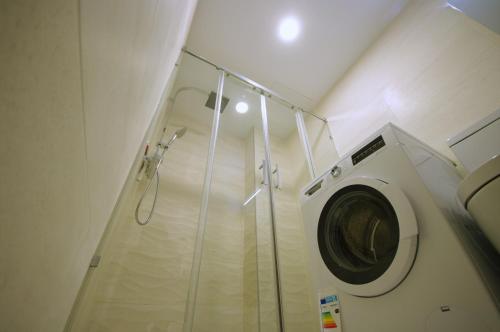 una lavatrice in un bagno con doccia di Livingtarifa Ventura Levante a Tarifa