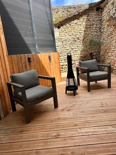 two chairs and a lamp sitting on a wooden deck at Au Petit Langres Logement Centre-Ville in Langres