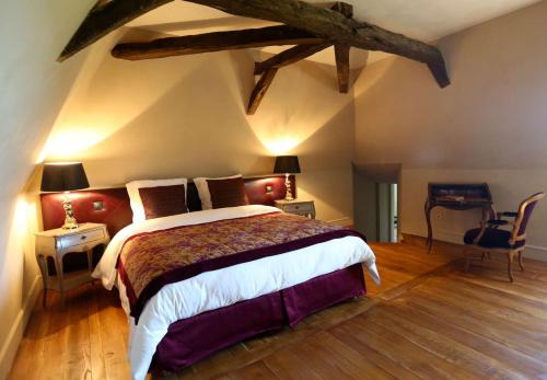 a bedroom with a large bed and a wooden floor at Château de La Mar Chambres d'Hôtes in Jongieux
