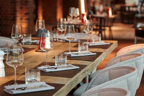 a long wooden table with wine glasses and napkins at Steigenberger Hotel Hamburg in Hamburg