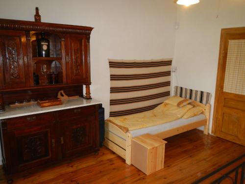 1 dormitorio pequeño con 1 cama y armario de madera en Berki Porta Vendégház, en Dinnyeberki