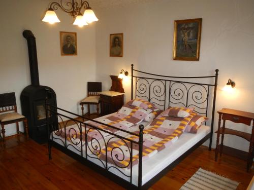 a bedroom with a bed and a wood stove at Berki Porta Vendégház in Dinnyeberki