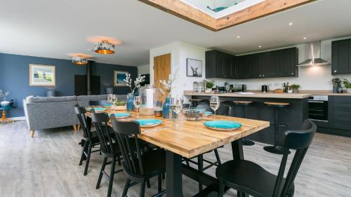 a kitchen and dining room with a wooden table and chairs at Cleifiog Fawr in Valley