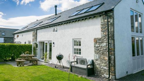 a white house with solar panels on the roof at Cleifiog Fawr in Valley
