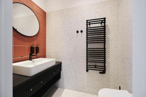 a bathroom with a white sink and a mirror at Aiden by Best Western Lodz in Łódź