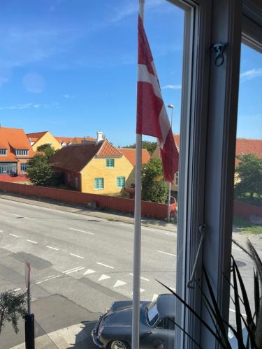 a view of a street with a flag in a window at Plesners Badehotel in Skagen