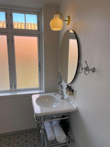 a bathroom with a sink and a mirror at Plesners Badehotel in Skagen