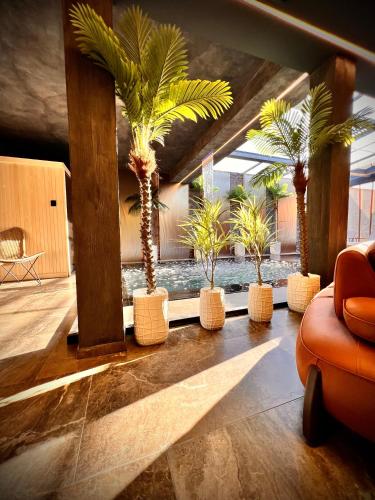 a lobby with palm trees in a room at Motel Villa Princi in Kosovo Polje