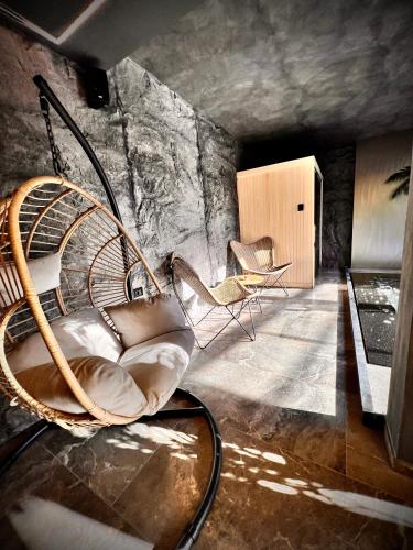a room with a rattan chair and a table at Motel Villa Princi in Kosovo Polje