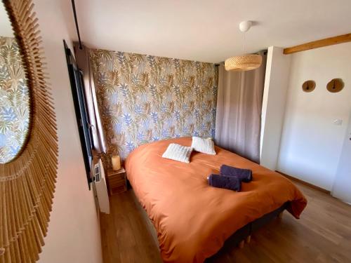 a bedroom with a bed with two blue towels on it at Domaine aux souvenirs denfance in Bénaix