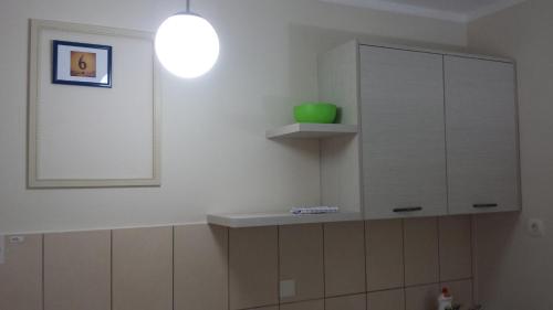 a kitchen with a white cabinet and a green bowl at Apartments Fortunella in Budva