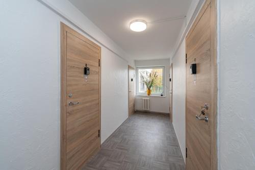 a hallway with wooden doors and a hallway with a window at Pramonės Apartment #11 by PoloApartments in Kaunas