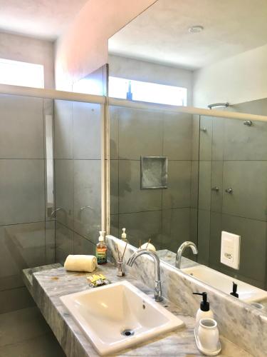 a bathroom with a sink and a large mirror at Pousada Recanto Ha Mar in Maceió