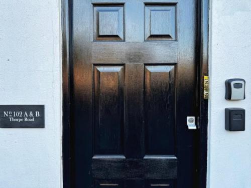 a black door with a sign in front of it at Luxury One Bedroom Apartment in Norwich