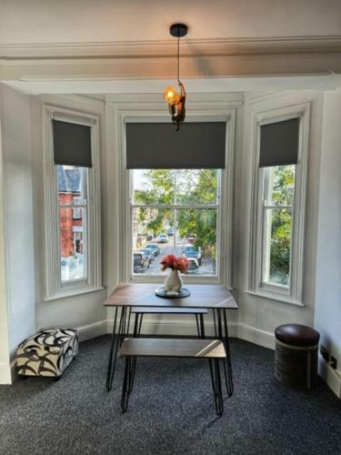 a room with a table with a vase of flowers on it at Luxury One Bedroom Apartment in Norwich