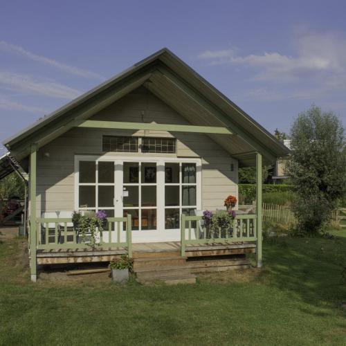 a small house with a porch with flowers on it at de Bosuil in Steensel