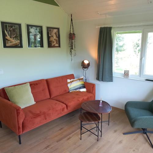 a living room with a red couch and a table at de Bosuil in Steensel