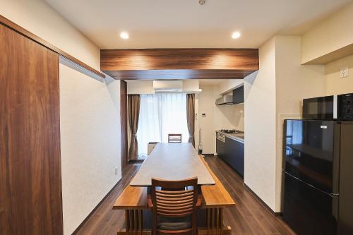 a kitchen with a long wooden table and a refrigerator at Asakusa Eight -Tokyo Condominium Hotel- in Tokyo