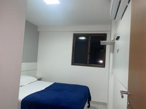 a small bedroom with a bed and a window at Apt 02 quartos em Ponta Verde in Maceió
