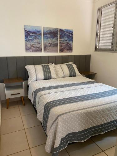 a bedroom with a bed with three paintings on the wall at Apartamento Firenze in Franca