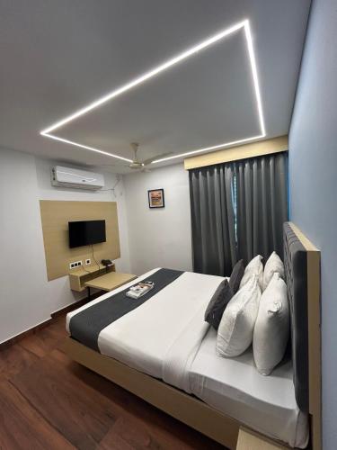 a bedroom with a bed and a desk and a television at Wild Wings Premium Hotel in Hyderabad