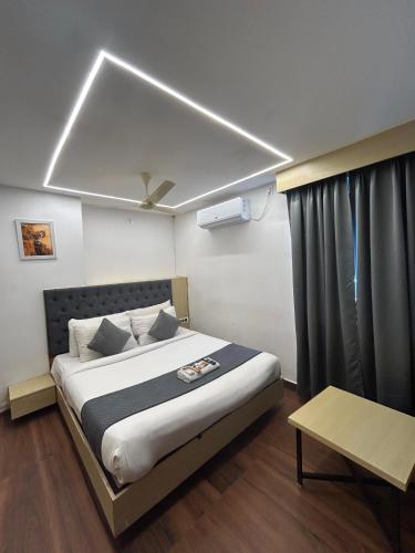 a bedroom with a large bed with a ceiling at Wild Wings Premium Hotel in Hyderabad